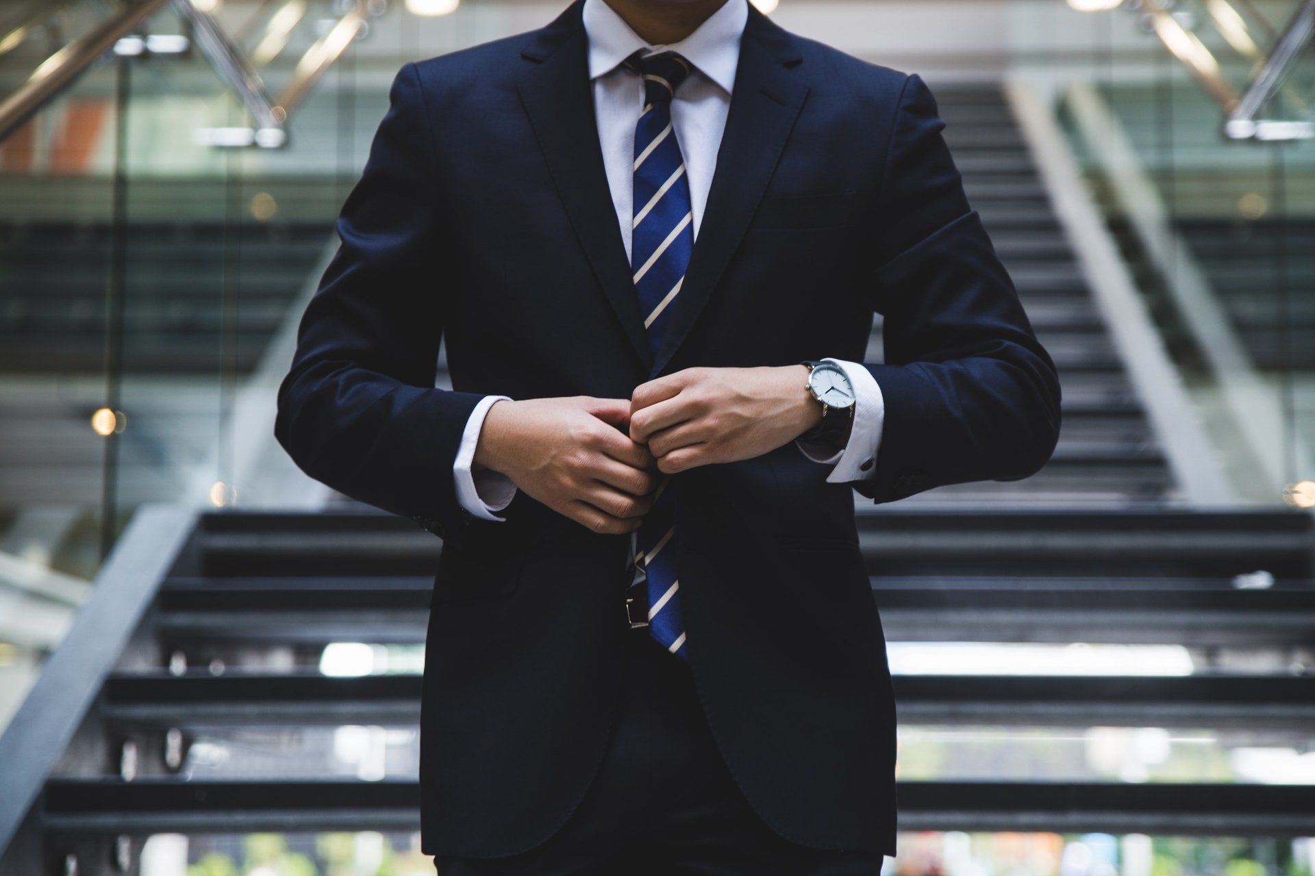 LockJaw process server in a navy suit buttoning his jacket